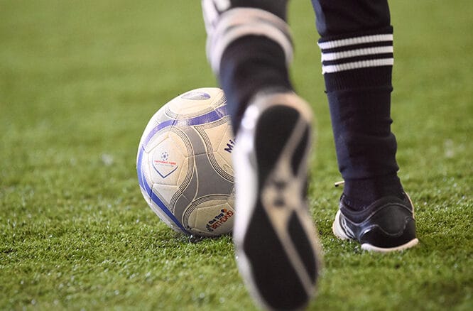 Toddler kicking soccer ball during Mighty Tykes class at Milwaukee Yard indoor turf field in Oak Creek WI