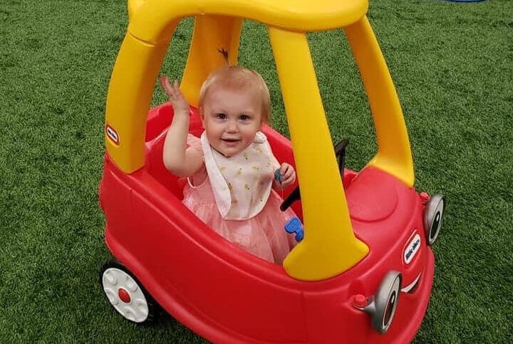 Child in a cozy coupe on a sports field during Easter Egg Hunt at Milwaukee Yard Oak Creek WI