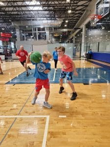 Summer FUN Camp child playing basketball on indoor courts at Milwaukee Yard Oak Creek WI