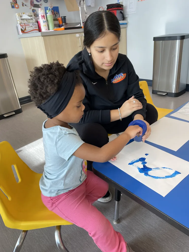 Preschool learning at Milwaukee Yard licensed daycare in Oak Creek, children ages 3 to 4 working on puzzles and art craft with teacher