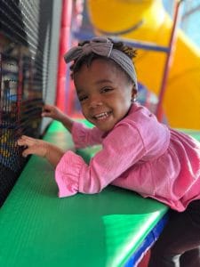 Child on 5 level indoor play tower with slides and tunnels at Milwaukee Yard Playroom in Oak Creek WI