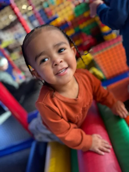 Child climbing 5 level play tower during large motor time at Active Childcare Milwaukee Yard