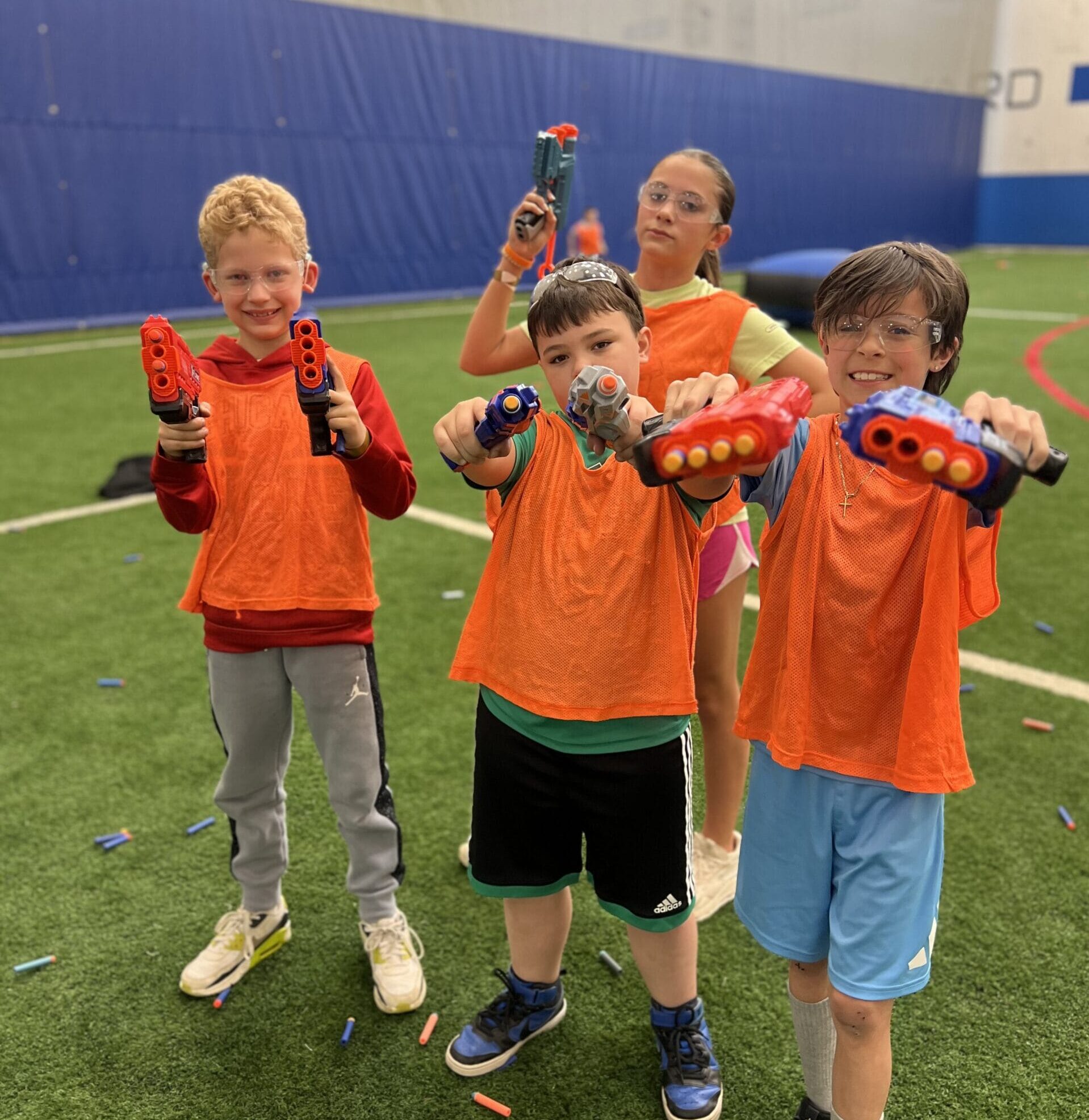 Kids playing Nerf War on indoor turf field during birthday party at Milwaukee Yard Oak Creek WI