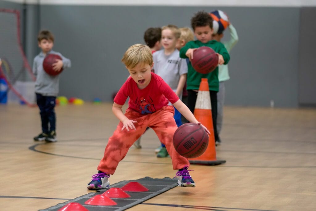 Children practicing dribbling drills during youth basketball class at Milwaukee Yard Oak Creek WI